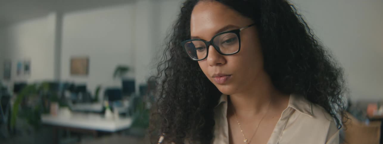 Woman uses a computer while alone at the office