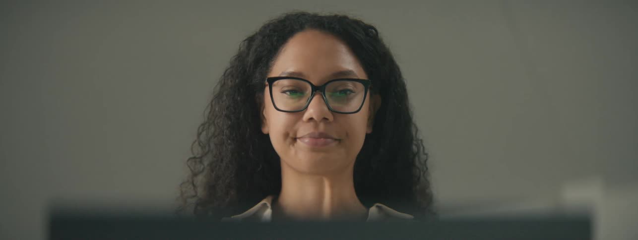 Woman talking in front of an open laptop