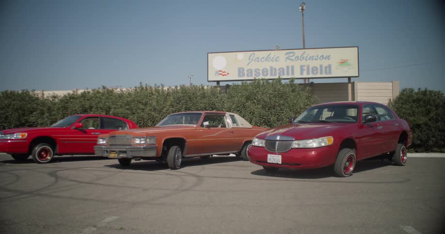 A few old cars are parked