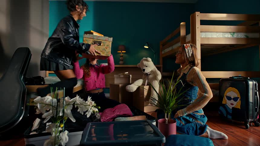 College students high five while they unpack in their shared dormitory