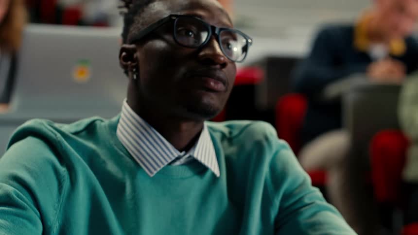 Man in classroom concentrating writing