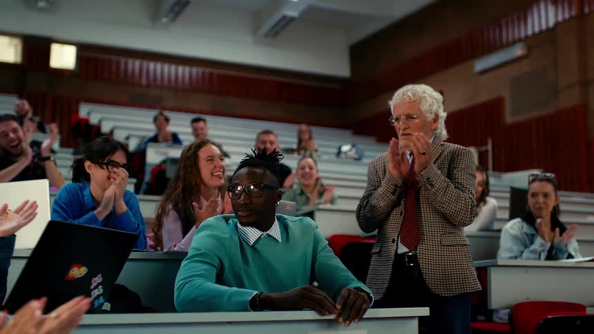 Teacher waking up a student who is sleeping in the classroom with a clap of the whole class