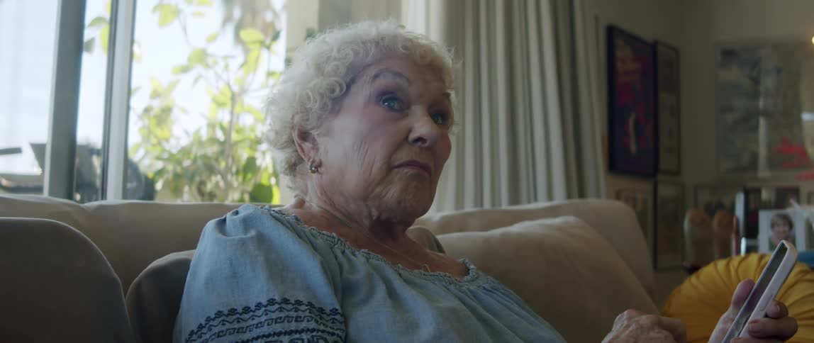 Elderly lady using smartphone and looking to the side attentively
