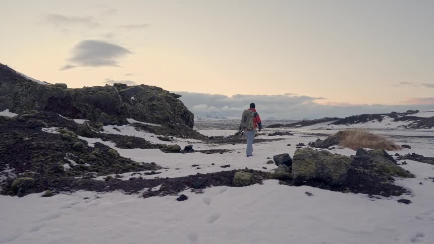 Man walking through a snowy landscape on a misty morning
