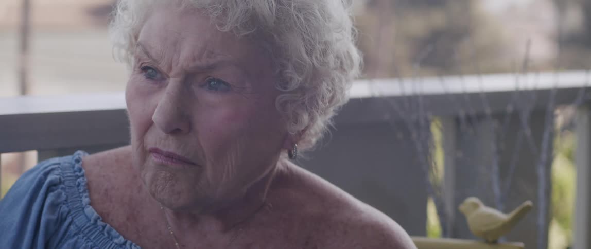 Elderly lady sitting in a backyard