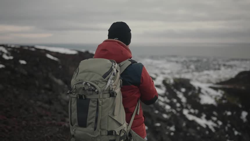 Photographer in a natural area of a snowy mountain using a professional camera with a zoom lens