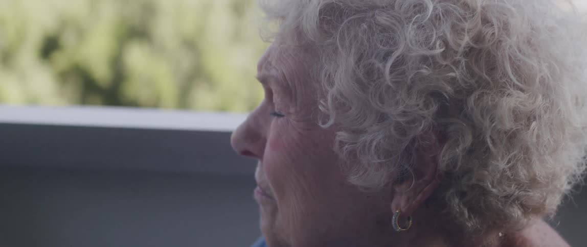 Close up of the face of an elderly woman sitting at home
