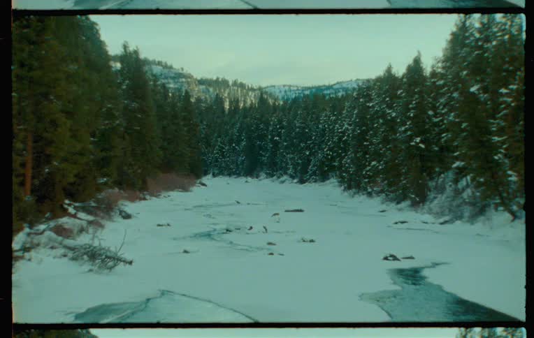 A winding river flows through a snowy forested landscape