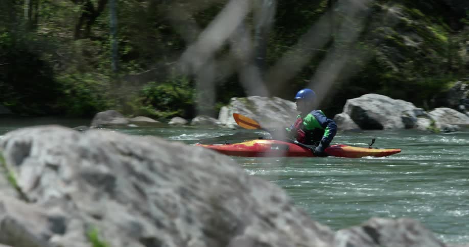 A man is kayaking down a river