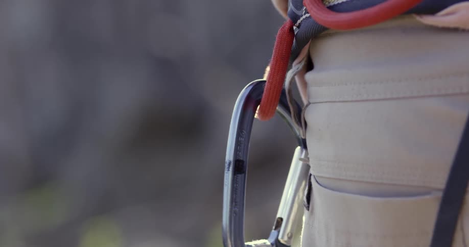 Rock climber attaching a carabiner to a loop on their belt