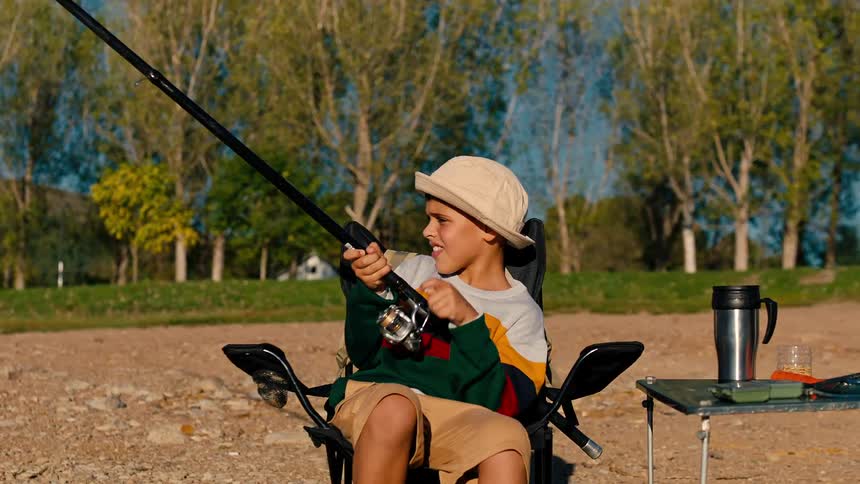 Boy pulling the string of a fishing rod while sitting