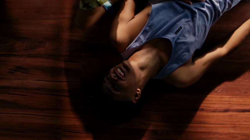 Brothers lying on the wooden floor look into each others eyes until they laugh
