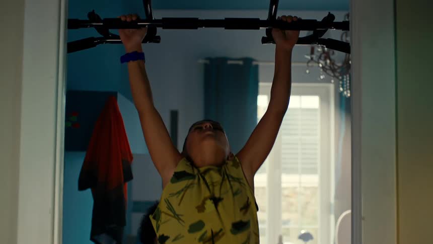 Boy doing pullups with help from a friend