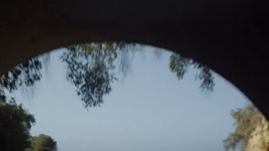 Upward moving view during daytime passing through a tunnel