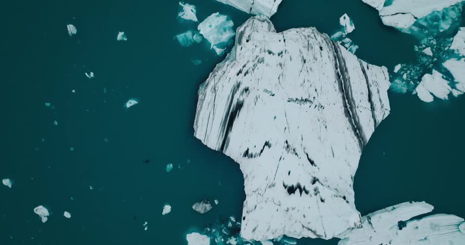 Smaller pieces of sea ice float near icebergs off an arctic coast