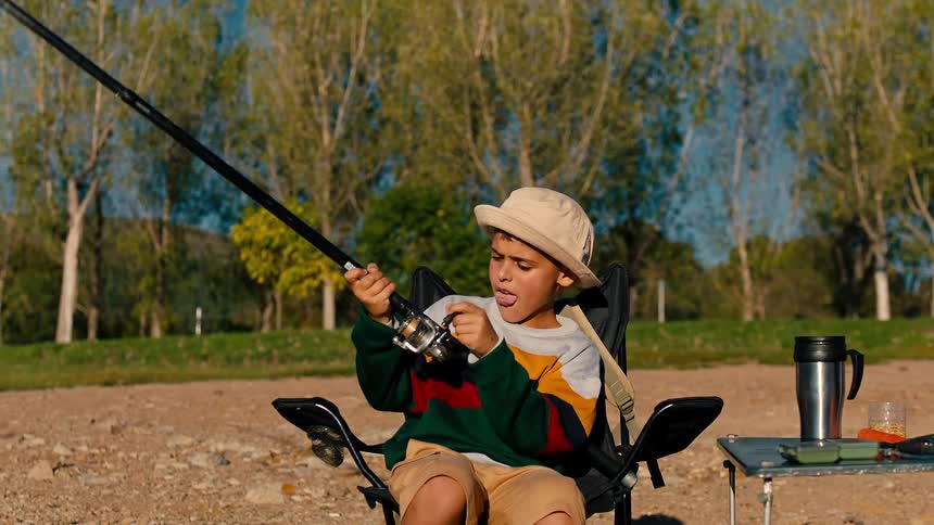 Boy sitting handling a fishing rod