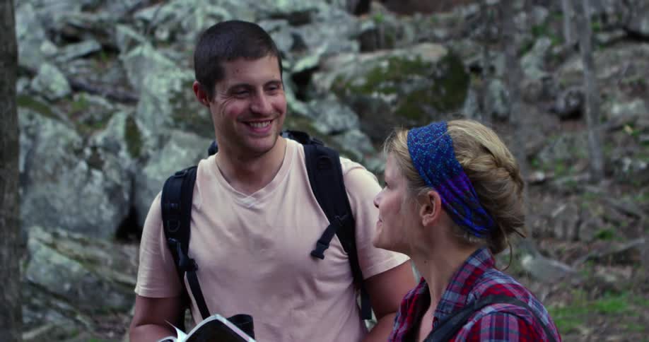 Man and woman happily discussing something about their surroundings  while she holds a book in front of her