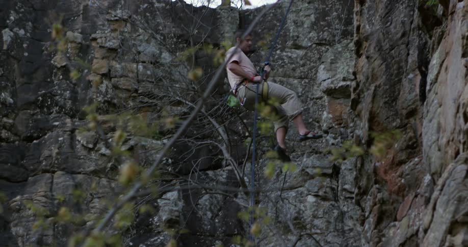 A man rappels down a rock face