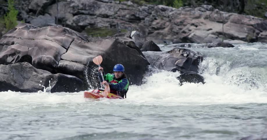 A man kayaking down a small drop