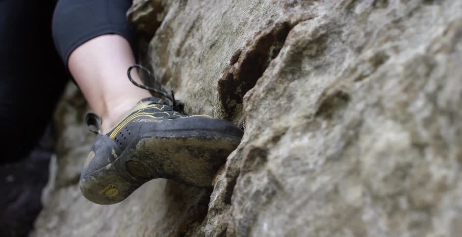 A woman climbing a rocky wall