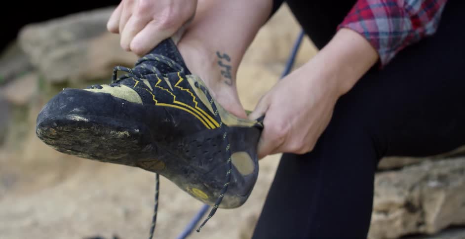 Rock climber resting their foot while holding onto their shoe