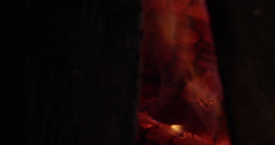 Flames flickering from burning logs in a fireplace