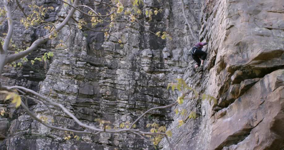 Person climbing up a steep cliff