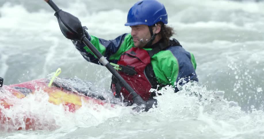 A man is kayaking down whitewater rapids