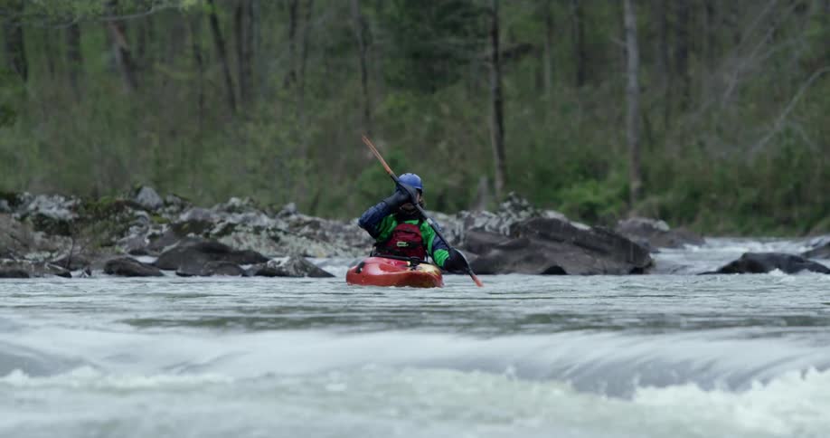Kayaker traversing a fairly smooth moving river