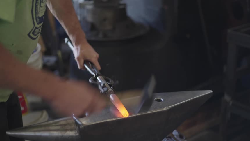 A clip of a blacksmith cutting an iron