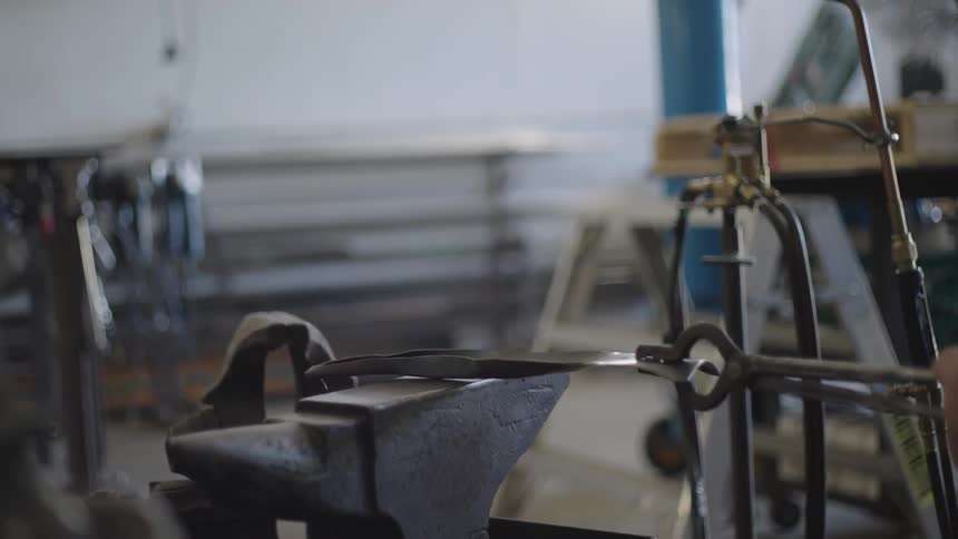 Blacksmith shapes metal with a hammer