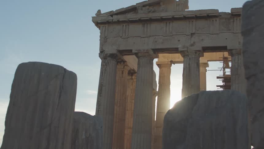 The sun shines through the columns of the parthenon