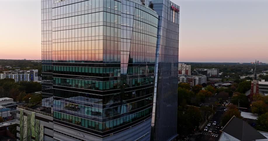 Aerial view of a modern mirrored building in a city in the late afternoon