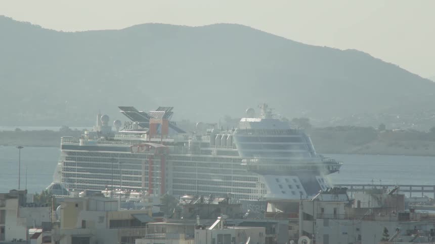 Large cruise ship docked near a coastal town