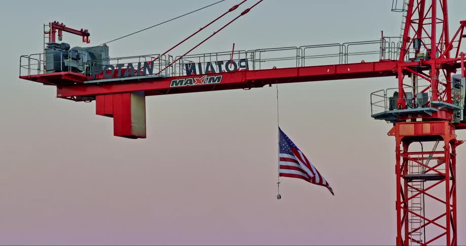 Red construction crane with an american flag
