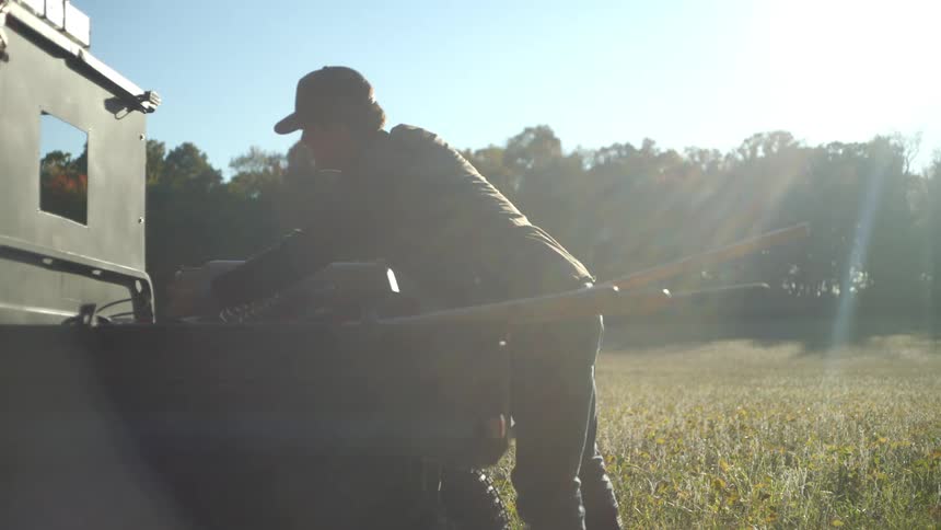 Man taking an animal crate from the back of a vehicle
