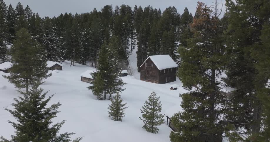 Aerial of cabins in the woods coverd in snow