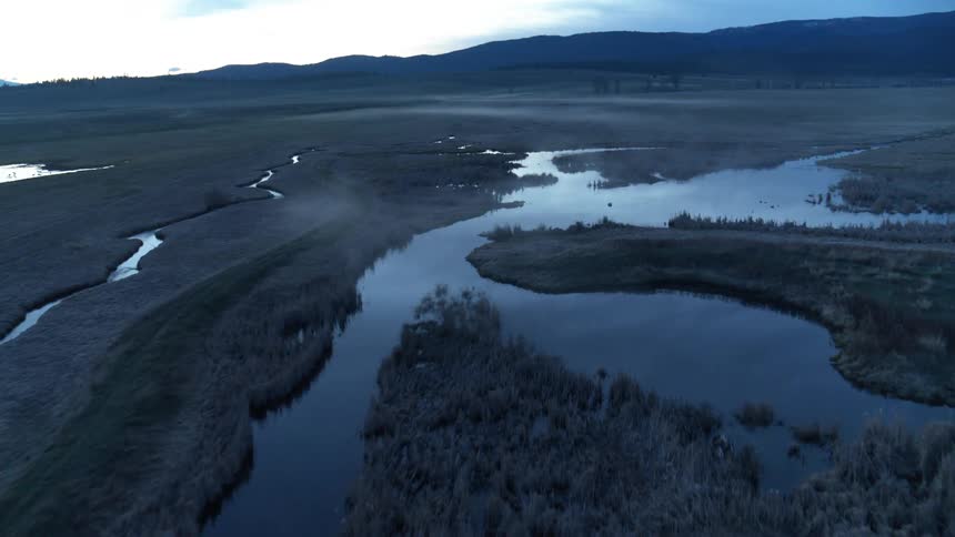 Aerial landscape of a river and lakes in a region with vegetation and mountains in the background