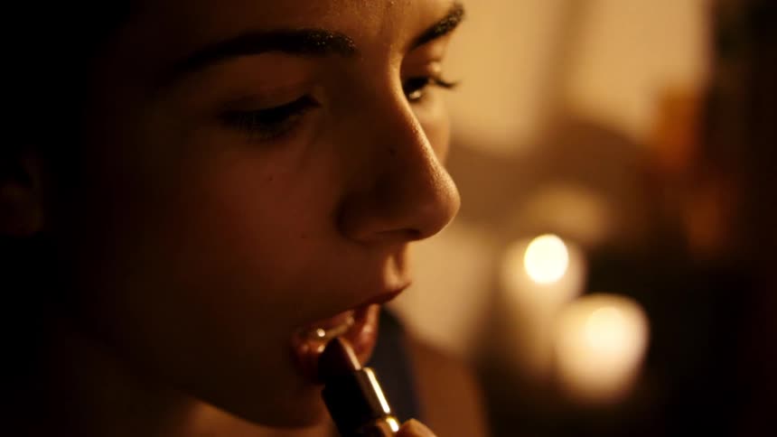 Woman putting on lipstick