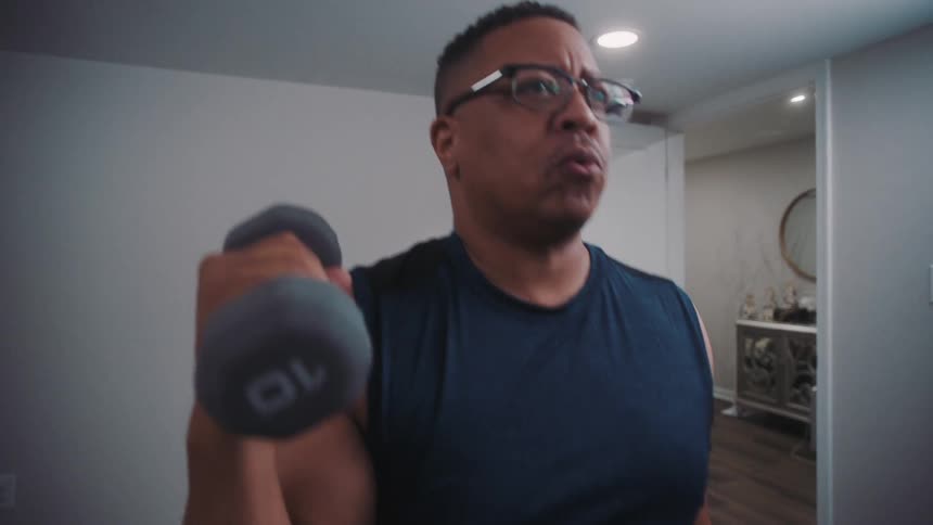 A man is lifting weights at home