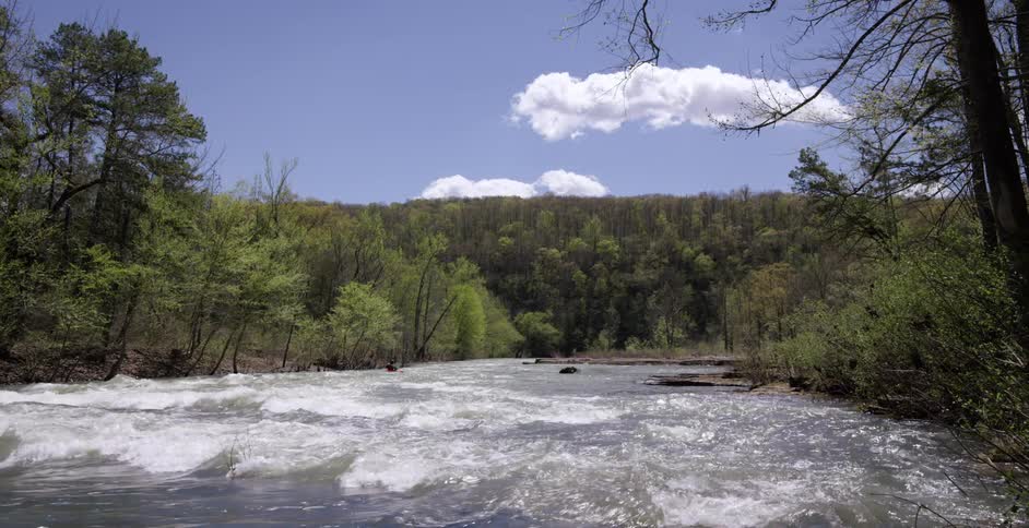 Person kayaking down a large river