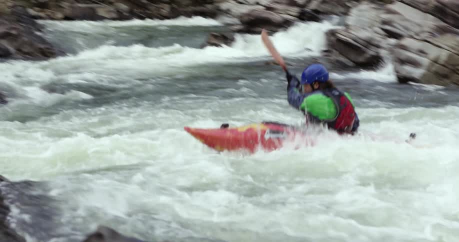 Person kayaking down rapids