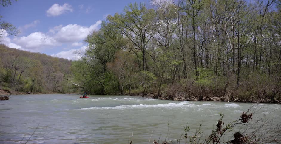 Kayaker moving down a fairly calm river