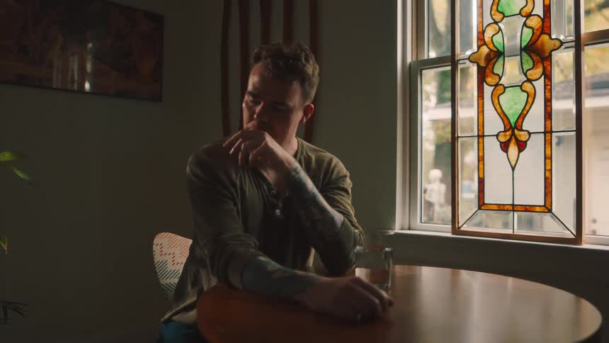Man sitting at table with eyes closed