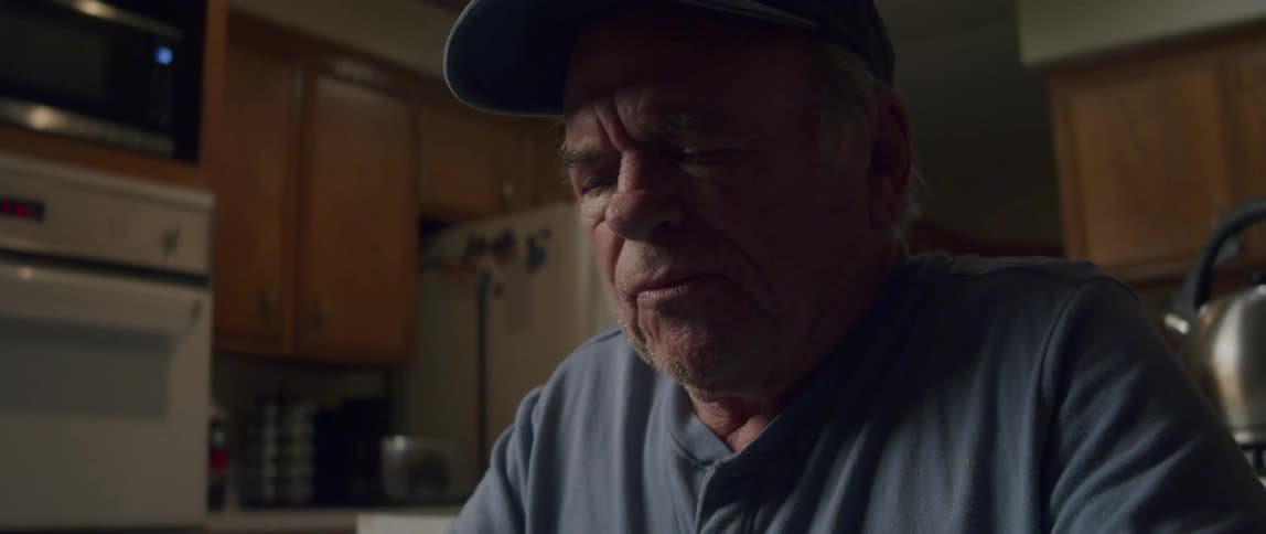 Elderly man sitting looking through documents