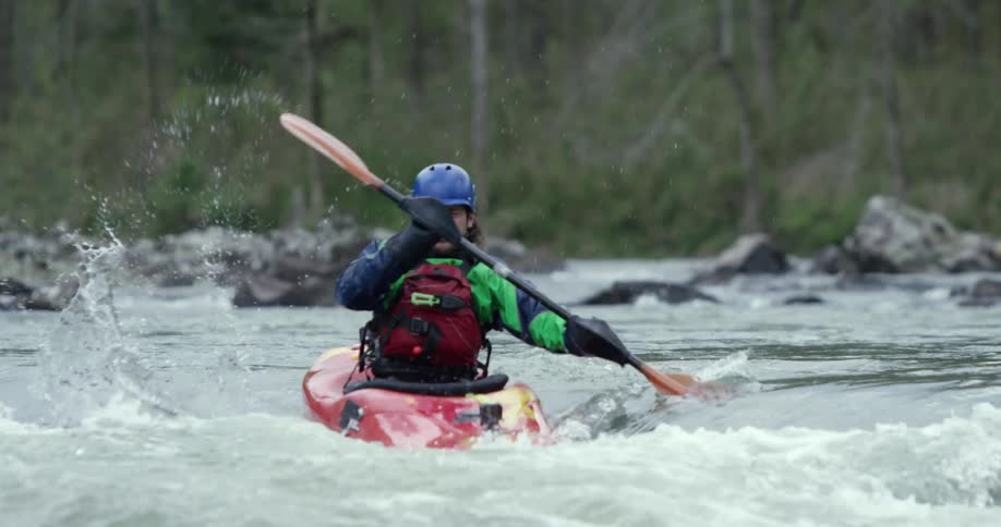 A man kayaking through some moving water