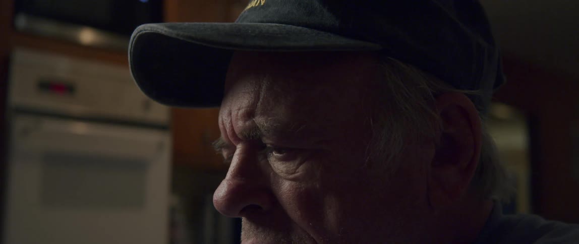 Elderly man sitting with cap