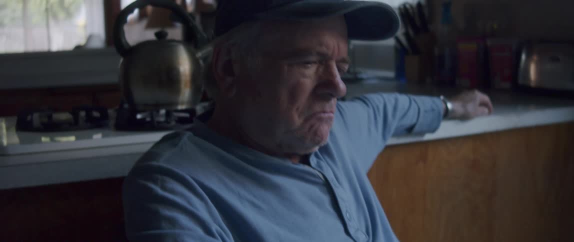 Elderly man sitting looking at documents and getting thoughtful