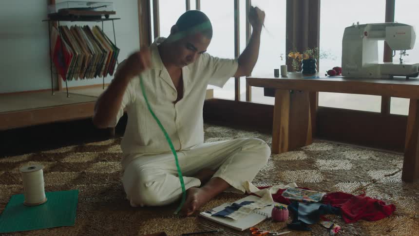 A tailor measuring pieces of cloth in his workshop