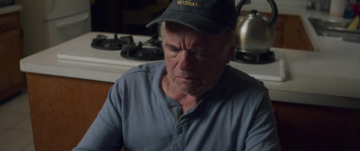 A man is reading in his kitchen
